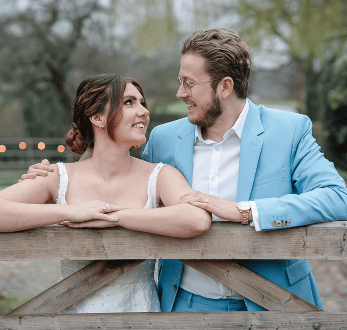 Romantic couple smiling at each other during outdoor wedding photoshoot, showcasing love and happine.
