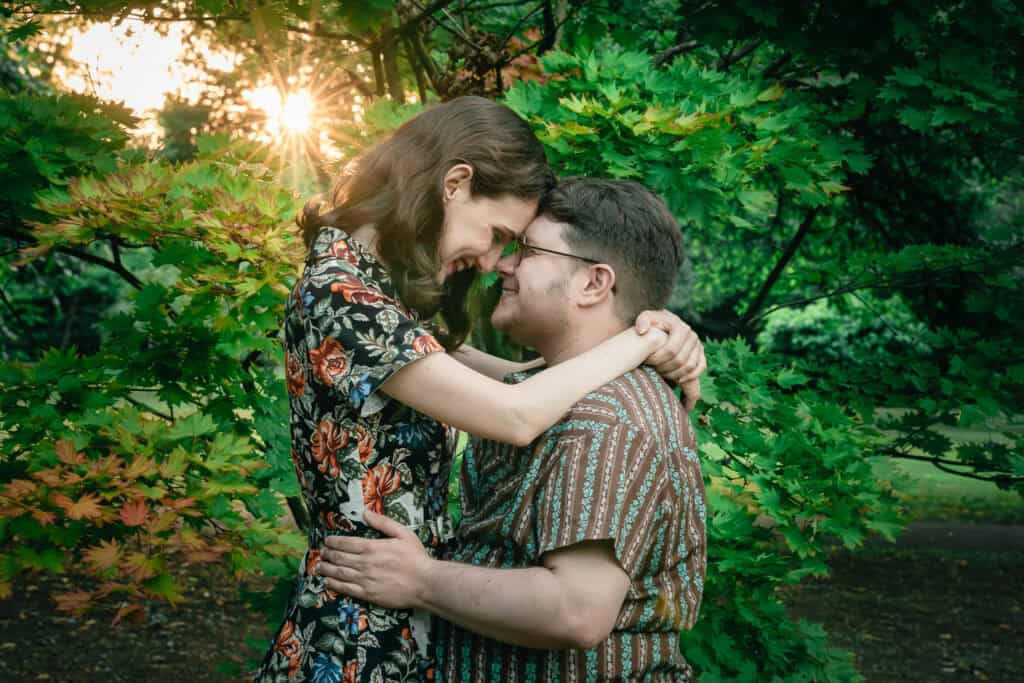 a couple hug by a tree in manchester