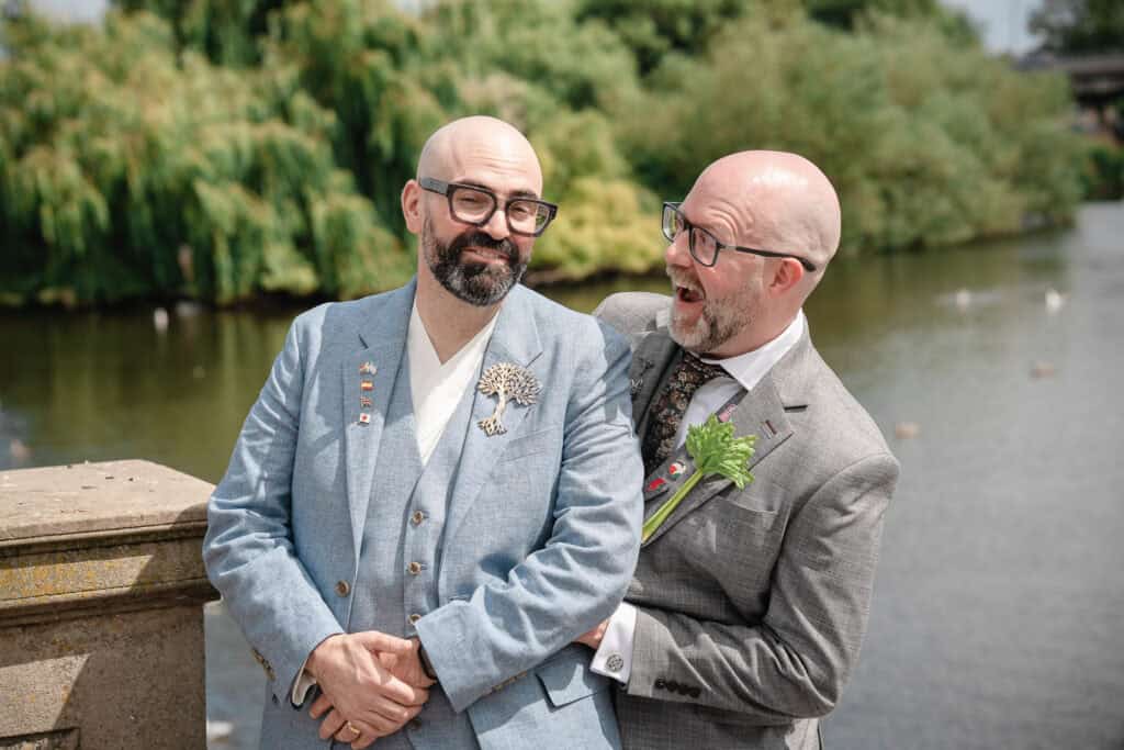 two grooms by the river in derby laughing with each other